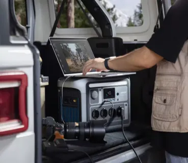 Anker SOLIX C1000 im Kofferraum – Laptop und Kameraobjektiv angeschlossen