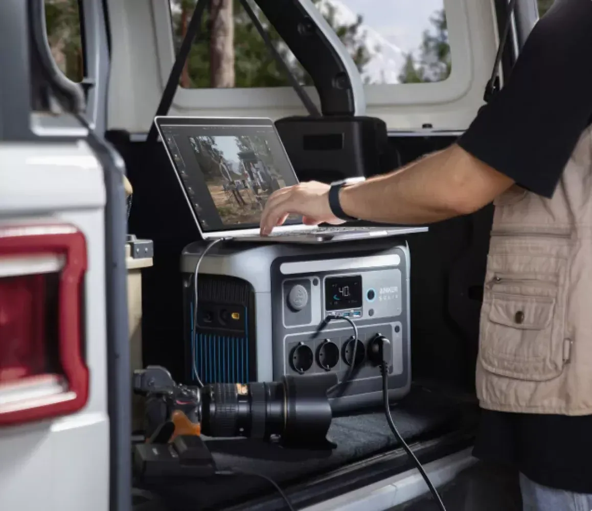 Anker SOLIX C1000 im Kofferraum – Laptop und Kameraobjektiv angeschlossen